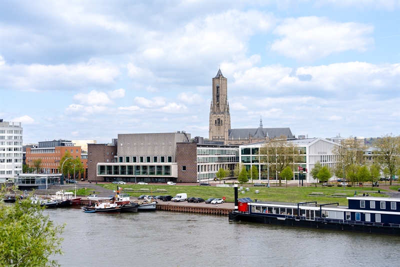 Het provinciehuis in Arnhem, met op de voorgrond de Rijn waarin bootjes liggen.