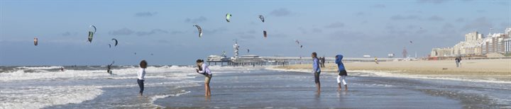 Het strand van Scheveningen, met mensen die met hun voeten in de zee staan