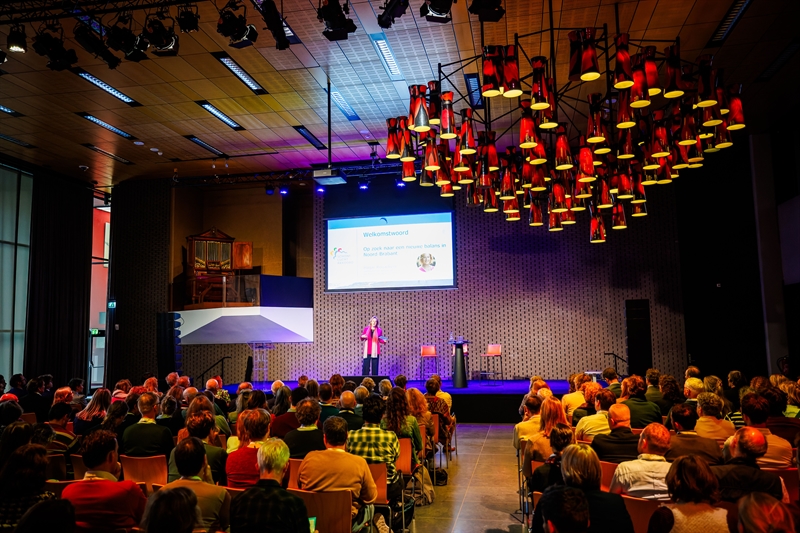 Gedeputeerde Hagar Roijackers opent het congres vanaf het podium.