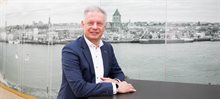 Wethouder Erik Faber poserend voor een oude zwart-witfoto van de stad Kampen