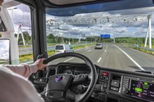 Uitzicht vanuit vrachtwagen op snelweg; op het dashboard de on-boardunit